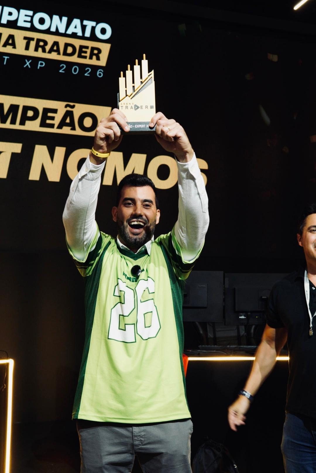 Alison Santos erguendo o troféu de campeão do Campeonato Arena Trader, na Expert XP 2026
